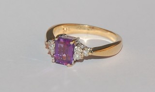 An 18ct yellow gold dress ring set a purple stone supported by 6 diamonds