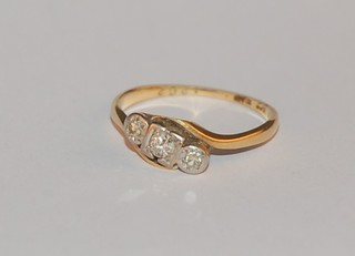 An 18ct yellow gold cross-over dress ring set 3 diamonds