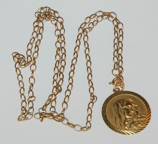A flat gold chain hung a 9ct gold pendant decorated The Virgin Mary