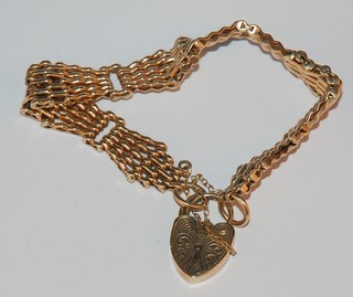 A gold bracelet with heart shaped padlock