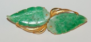 A 14ct gold bracelet with carved green hardstone panels in the form of a leaf