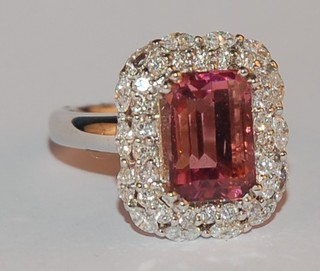 A lady's 18ct white gold dress ring set a pink tourmaline supported by diamonds