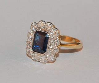 A lady's 18ct yellow gold dress ring set a lozenge shaped sapphire supported by numerous diamonds, approx 1.05/1.60ct