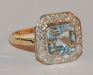A lady's 18ct yellow gold dress ring set a square cut aquamarine supported by numerous diamonds approx 0.65/2.50ct