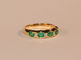 A lady's 18ct yellow gold half eternity/dress ring set emeralds and diamonds