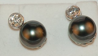 A pair of lady's diamond and black pearl ear studs approx 0.65 ct