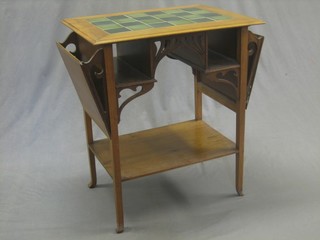 An Edwardian Arts & Crafts mahogany 2 tier occasional table with green tiled top, fitted various niches and pigeon holes and raised on square supports with outswept feet (2 feet f) 34"