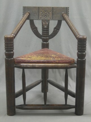 A  turned and carved oak corner chair with leather seat