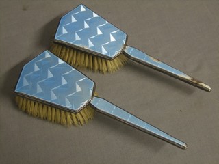 A pair of silver and enamel backed hair brushes