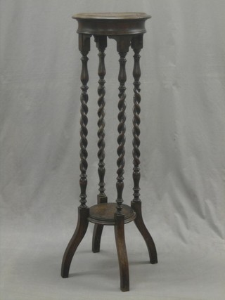 A circular oak 2 tier jardiniere stand, raised on spiral turned supports 12"
