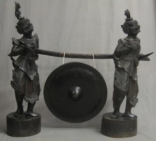 A handsome Eastern gong supported by 2 carved figures of warriors 40"