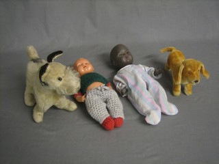 A cuddly figure of a small yellow dog 6" and 1 other, a black rubber doll and a celluloid doll