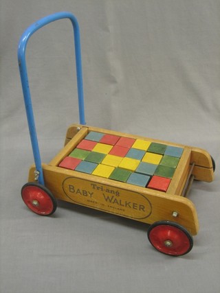 A wooden Triang baby walker containing various wooden blocks