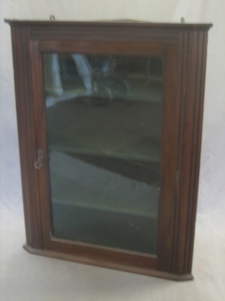 A 19th Century mahogany hanging corner cabinet the interior fitted shelves enclosed by a glazed panelled door 29" 