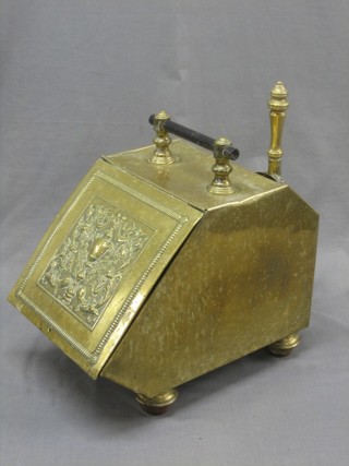 A Continental embossed brass coal bin with hinged lid complete with handle