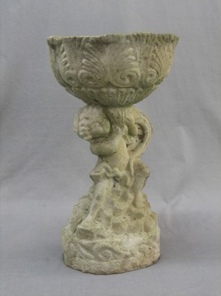 A weathered garden stoneware planter in the form of a cherub supporting a bowl 19"