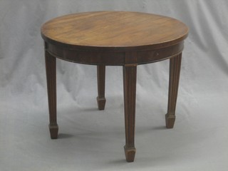 A circular Georgian style mahogany occasional table raised on square fluted tapering supports ending in spade feet 24"