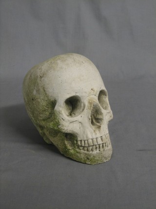A garden stoneware figure in the form of a skull 8"