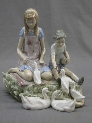 A Lladro figure in the form of boy and girl feeding ducks, no. 5303 base incised JU 9" (f and r)