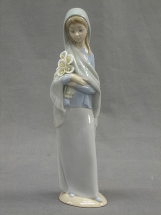 A Lladro figure of a standing girl with lilies 9"