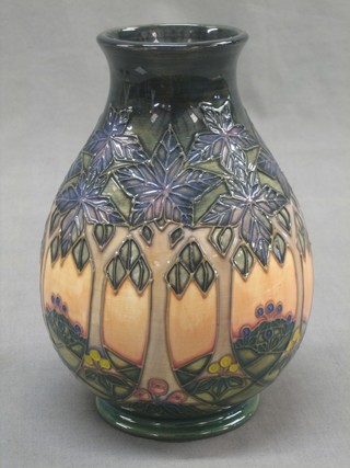 A Moorcroft pottery club shaped vase decorated stylised trees, base impressed Moorcroft with chamber stick mark to base 7"