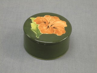 A Moorcroft pottery cylindrical green glazed jar and cover, the lid decorated Hibiscus  2"