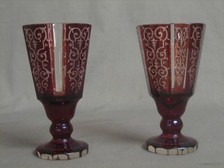 A pair of red Bohemian glass goblet shaped glasses, raised on octagonal bases 7"