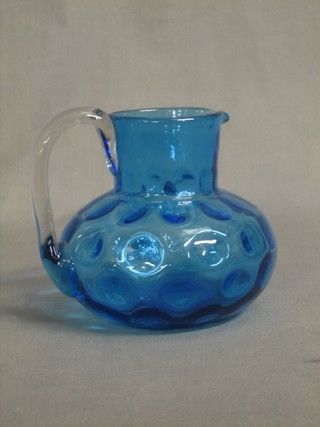 A blue dimpled glass jug with clear glass handle 5"