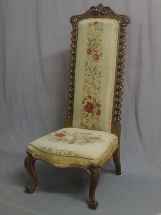 A handsome Victorian carved walnut high back nursing or Pre Dieu chair, with Berlin woolwork seat and spiral turned column decoration to the sides, raised on cabriole supports