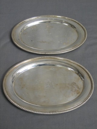 A pair of oval silver plated sauce boat stands with armorial decoration and gadrooned borders 7 1/2"