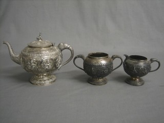 An Eastern embossed silver 3 piece tea service comprising teapot, sugar bowl and twin handled cream jug, 28 ozs