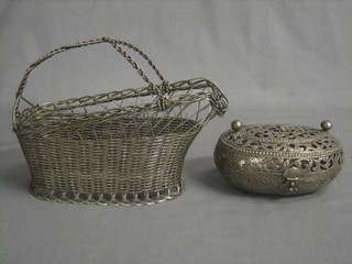 An oval embossed and pierced Eastern white metal box with hinged lid and a white metal wire work bottle holder