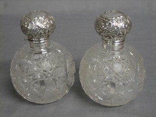 A pair of circular globular cut glass scent bottles with embossed silver stoppers, Birmingham 1901 4 1/2"
