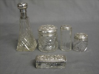 A waisted cut glass scent bottle with silver top, a cylindrical cut glass dressing table jar, 2 others and a rectangular  pin tray all with silver tops