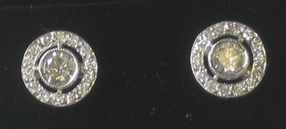 A pair of circular cut diamond ear studs surrounded by diamonds, approx 0.85ct
