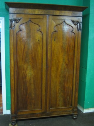 A Channel Islands William IV mahogany wardrobe with moulded cornice, enclosed by panelled doors, raised on bun feet 59"