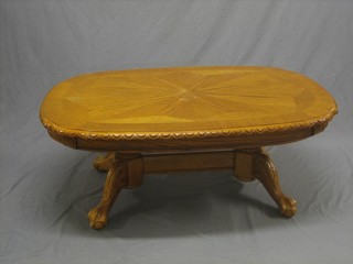 A German style carved oak oval coffee table, raised on tripod supports 50"