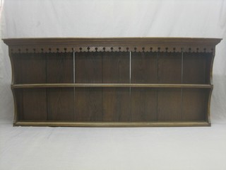 A carved oak dresser back with moulded and dentil cornice and pierced apron, fitted 2 shelves 73"