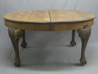 An Edwardian Chippendale style mahogany extending dining table, heavily carved throughout and raised on cabriole, ball and claw supports