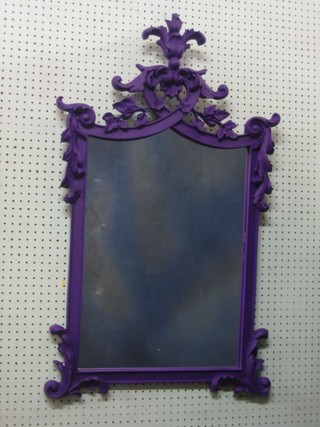 A shaped plate wall mirror contained in a decorative purple frame 24" x 17"