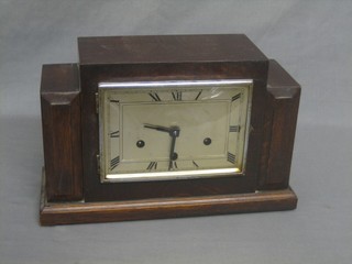 An Art Deco chiming mantel clock with square silvered dial with Arabic numerals, contained in an oak case