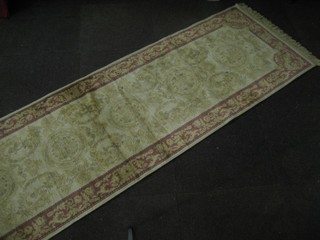 A contemporary beige and rose  ground Abusson style runner 110" x 30"
