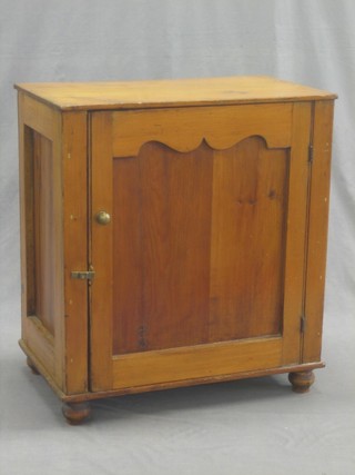A small Continental varnished pine cabinet, fitted shelves enclosed by an arch shaped panelled door 25"