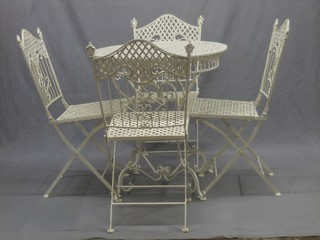 A pierced iron garden suite comprising circular garden table and 4 folding chairs