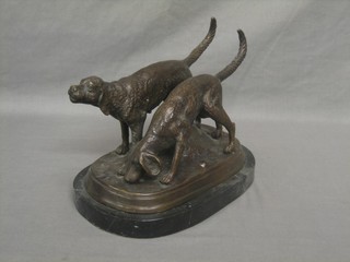 A bronze figure group of a pair of Blood Hounds, raised on an oval naturalistic base 7"