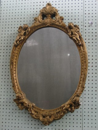 An oval plate mirror contained in a gilt frame decorated cherubs 26"