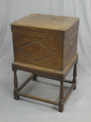 A carved oak "cellarette" with hinged lid, raised on turned and block supports 19"