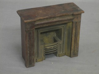 An Edwardian mahogany and metal dolls house fire place with metal ducks nest grate, contained in a mahogany surround 6"