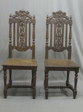 A pair of Victorian carved oak Carolean style high back hall chairs, raised on spiral turned supports