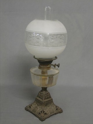 A Victorian glass oil lamp raised on a pierced iron base